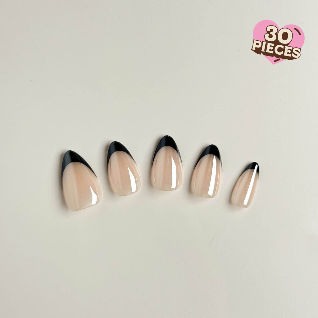 Fünf Justmee Press-on-Nägel in Mandelform mit präzisen schwarzen French Tips und glänzendem Nude-Untergrund im eleganten Tuxedo-Design.