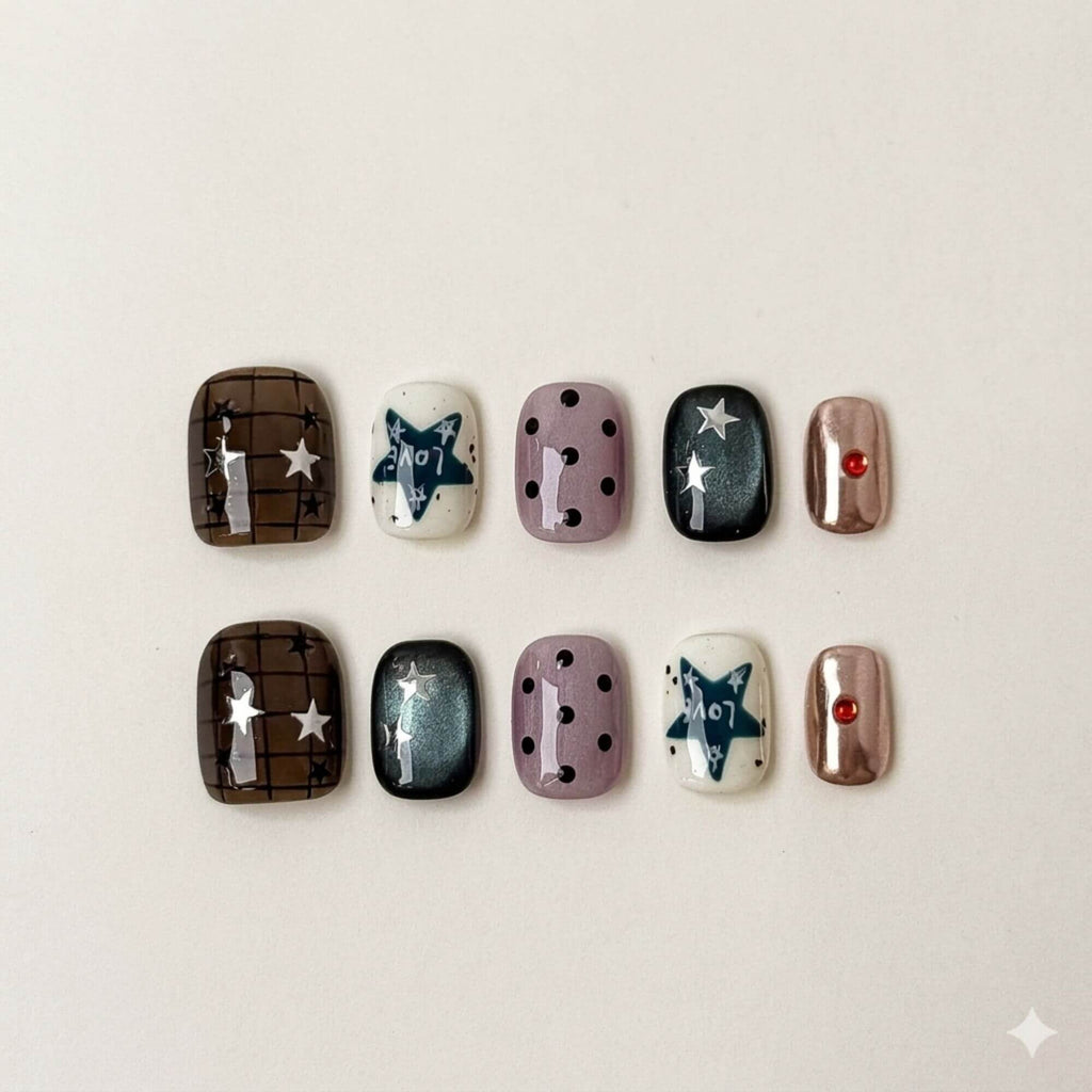 Eine Flatlay-Übersicht des 10-teiligen Celestial Grunge Kunstnägel-Sets, das einen Mix aus Chrome-, Sternen-, Karo- und Punkte-Designs in kurzer eckiger Form zeigt.