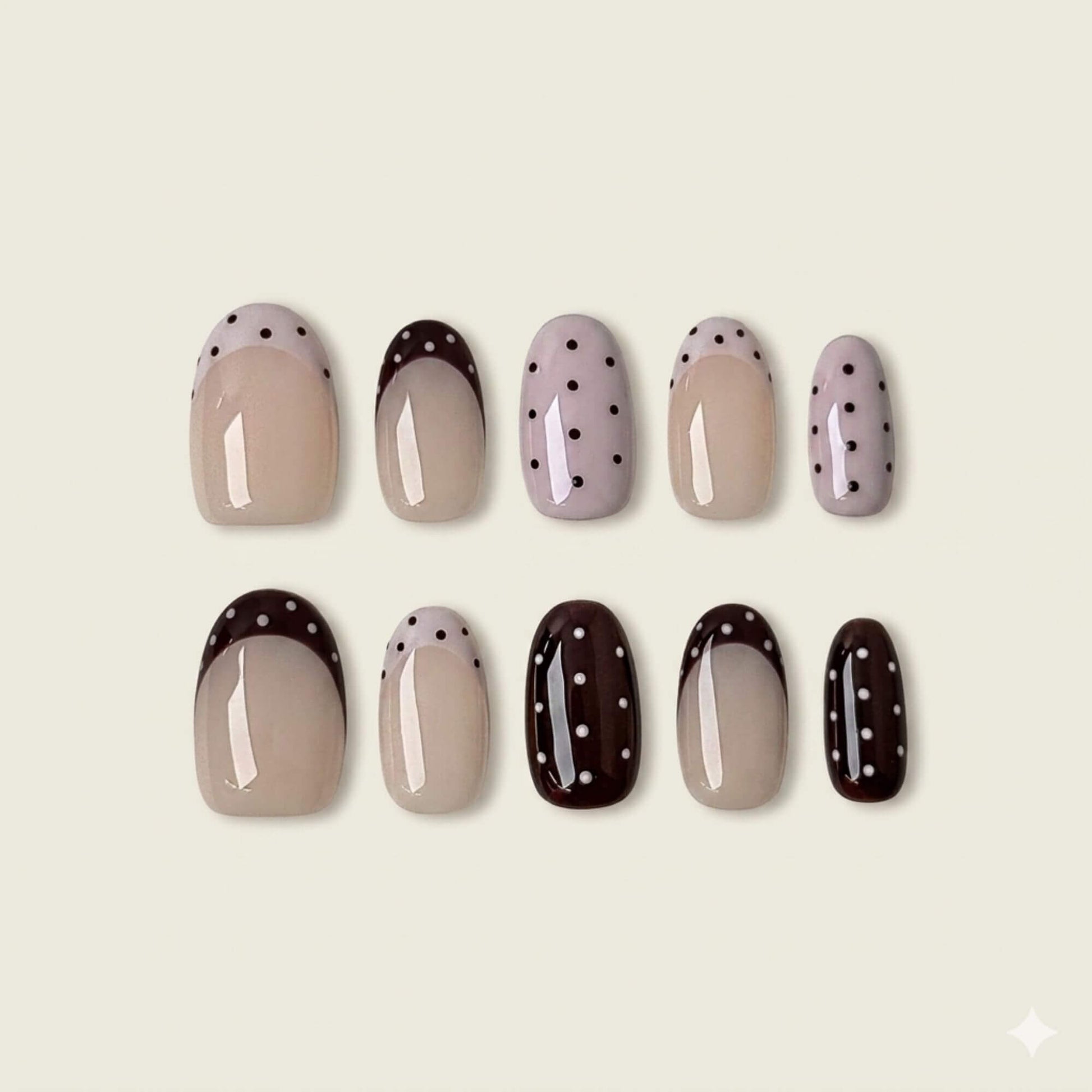 A top-down flat lay display of 10 handmade almond-shaped press-on nails from the Cocoa Dot collection, featuring espresso and cream polka dot French tips.