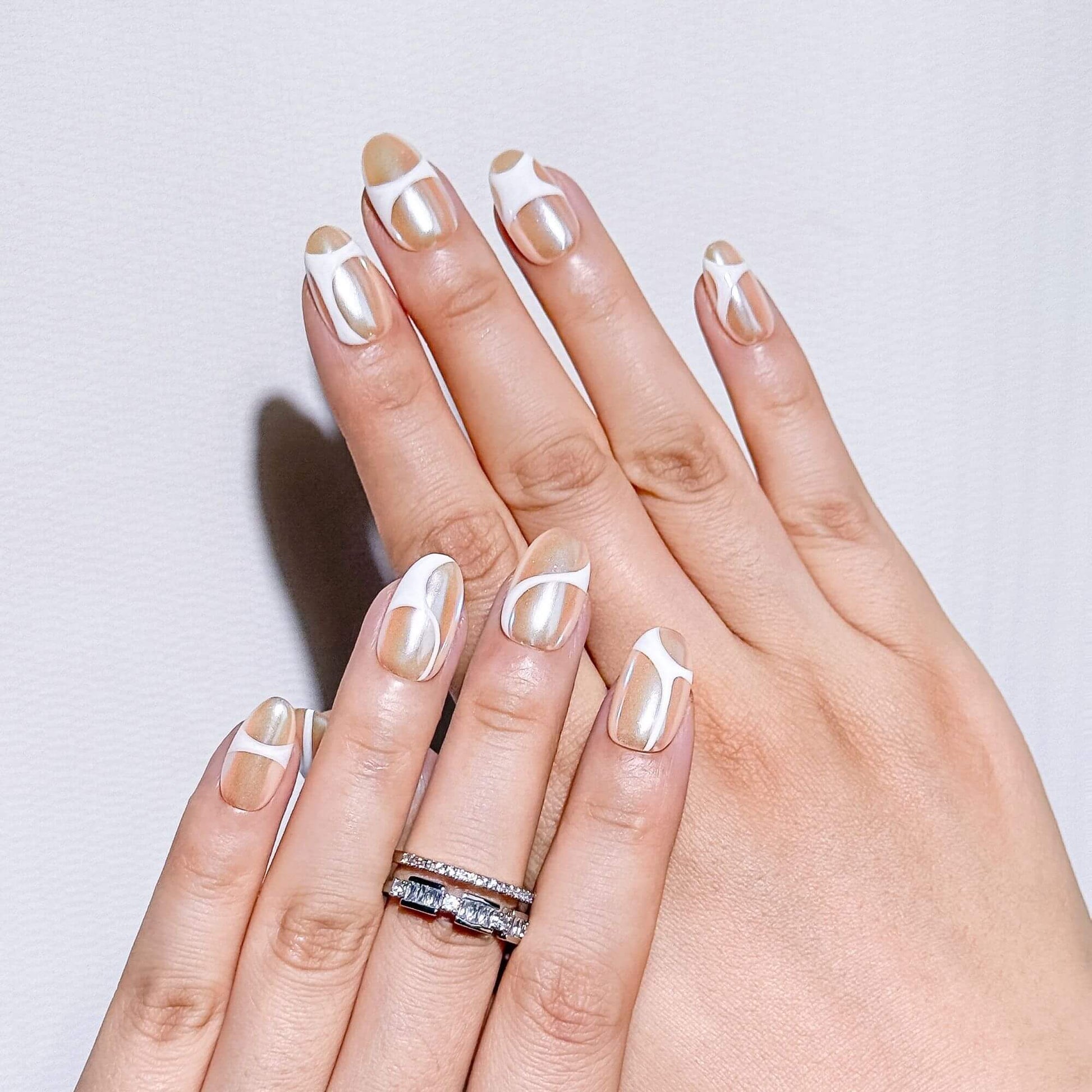 Professionelle Ansicht von handbemalten Champagne Glaze Swirl-Nägeln in ovaler Form für einen makellosen Look wie frisch aus dem Studio.