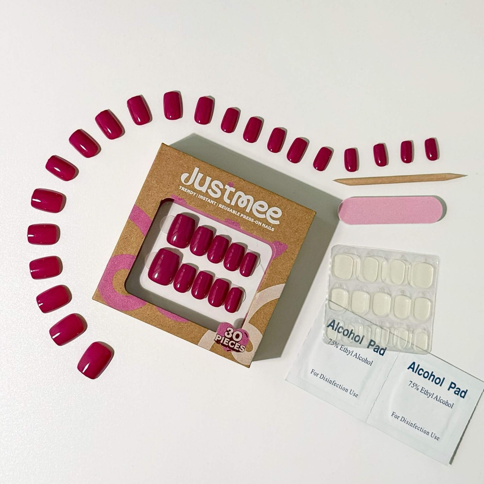 Complete Justmee press-on nail set including 30 magenta pieces, nail file, prep pads, and application stick.