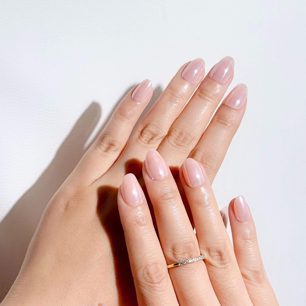 Elegant short almond press-on nails in nude pink pearl finish, perfect for a clean girl aesthetic.