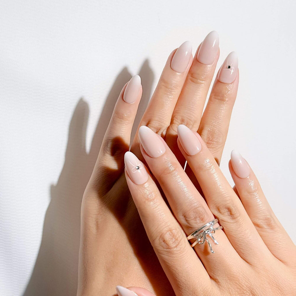 Elegant coquette aesthetic manicure with Justmee French ombre stick-on nails and 3D bow accents.