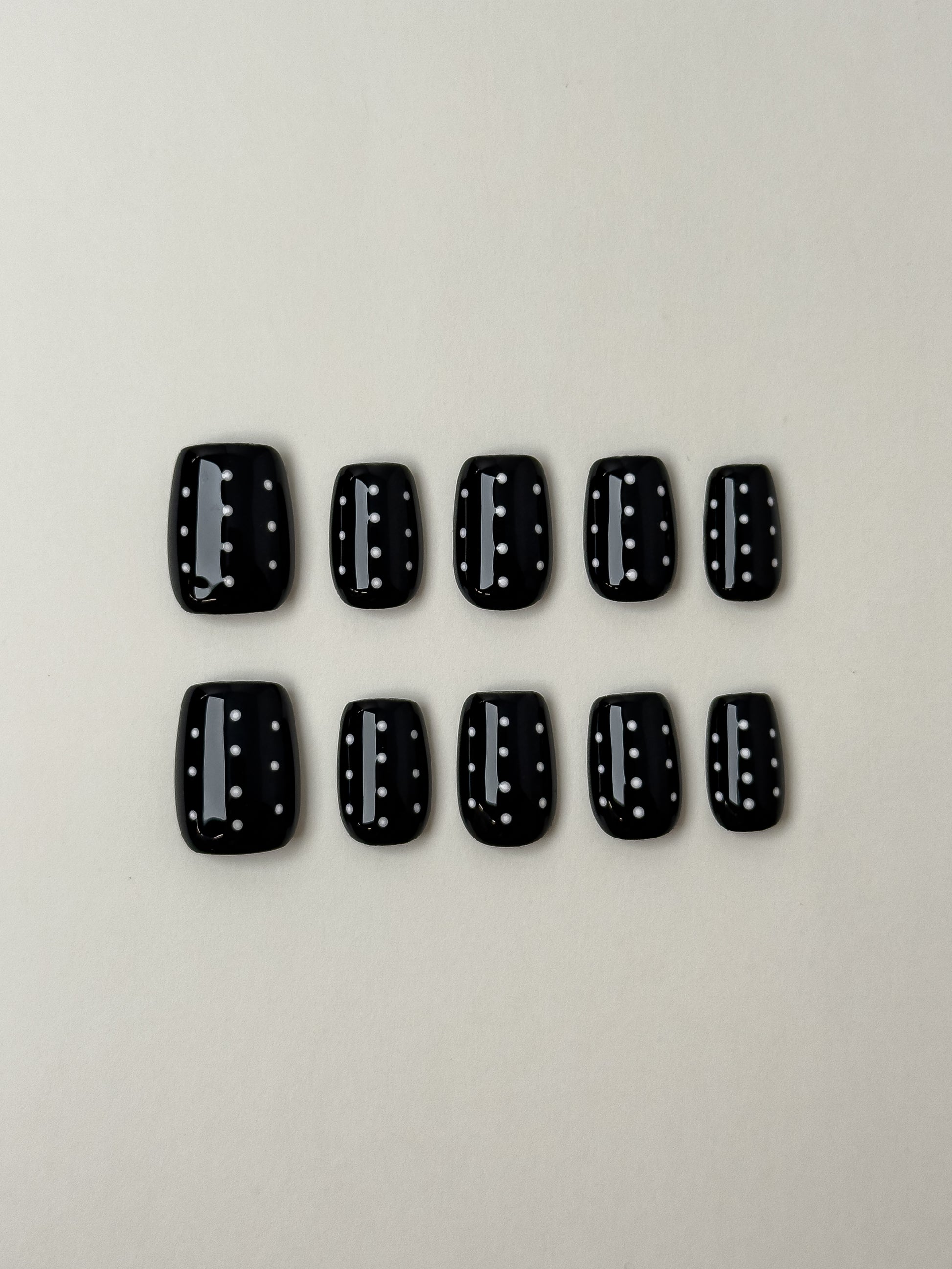 Glossy black short square press-on nails with white polka dot pattern from Justmee