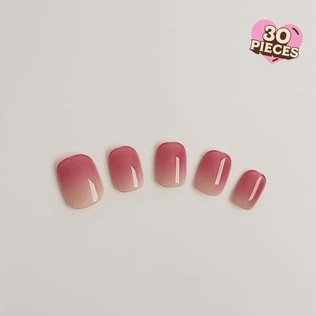 Eine Nahaufnahme von fünf Justmee Press-on-Nägeln mit einem weichen Farbverlauf von Rosé zu Nude, kurze runde Form mit glänzendem Finish.