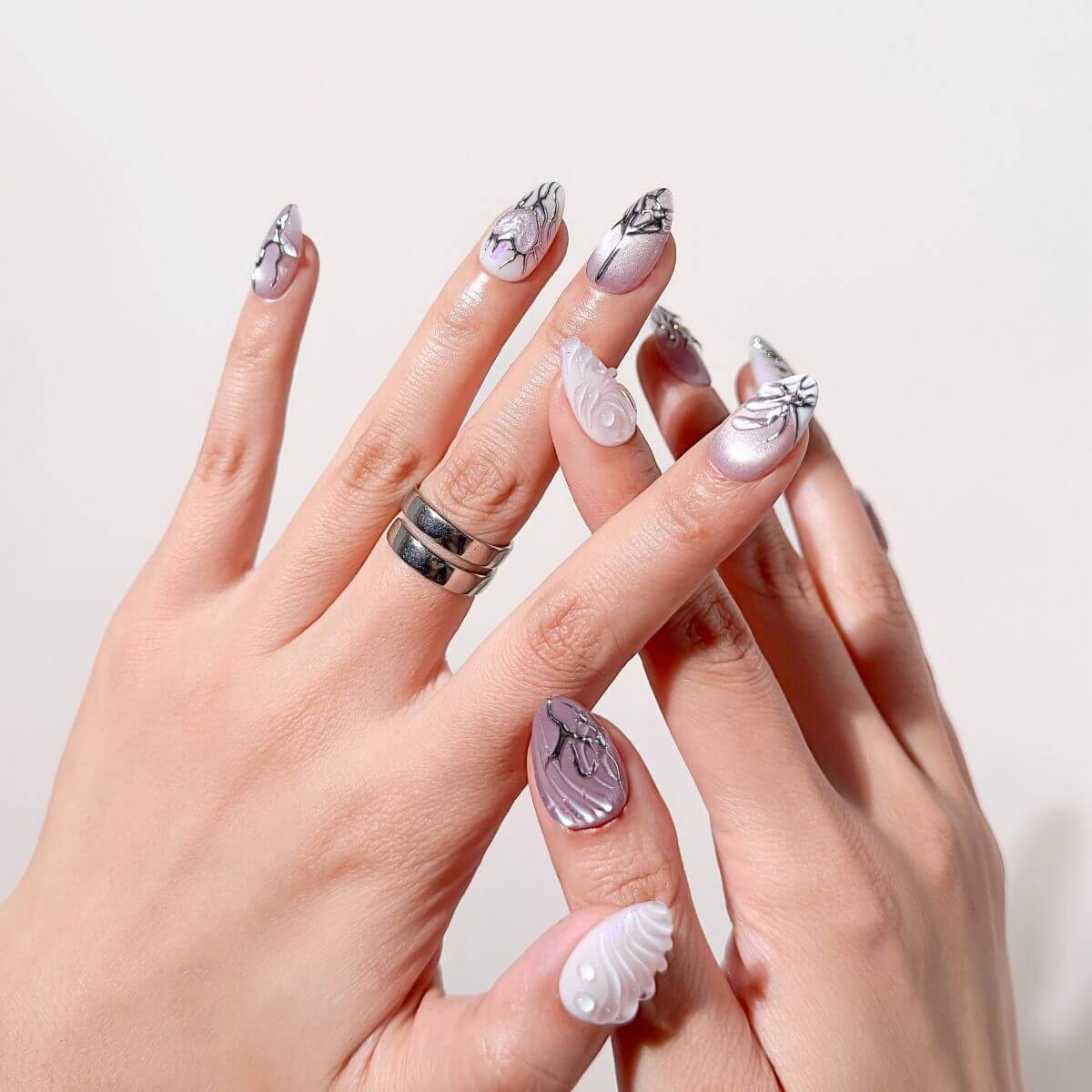 Handgefertigte Kunstnägel mit silberner Cyber-Nailart. Diese Gel-Nägel zum Aufkleben von justmee vereinen modernes Design mit einer einfachen Anwendung für eine langanhaltende Maniküre.
