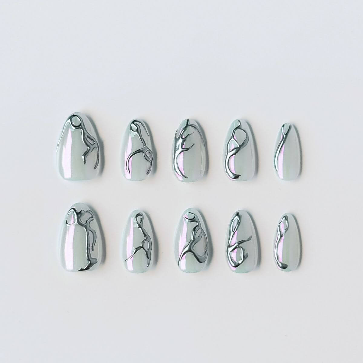 Ein 10er-Set handgefertigter Press-on Nails in Mandelform mit milchig-schimmernder Basis und silbernem 3D-Chrom-Design im futuristischen Y2K-Stil.