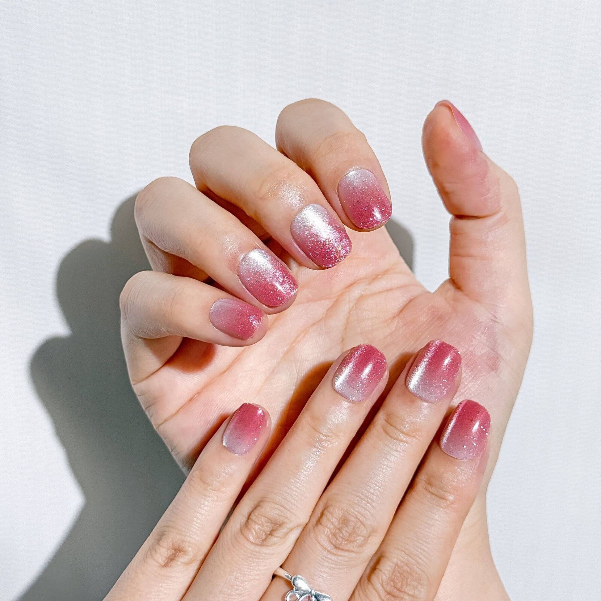 Ästhetische Ansicht der Sugar Plum Fade Press-on Nägel, hochglänzendes Design mit lila Glitzer-Ombré Effekt.