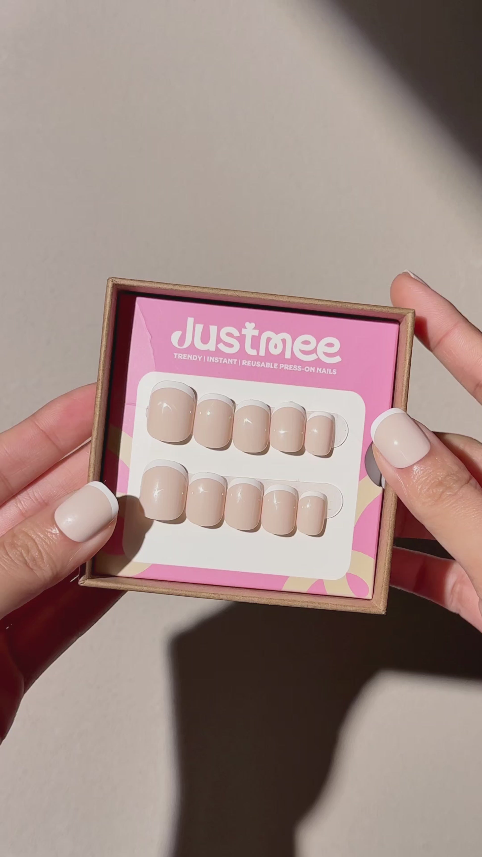 2 hands showing Justmee Vanilla Ice 30pcs Press-on nails set under natural light, and one hand shows the nails on hand, milky color with micro french white tip in short square oval shape