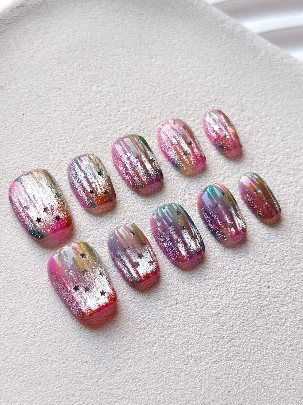Rainbow jelly press-on nails with silver glitter trails and star accents