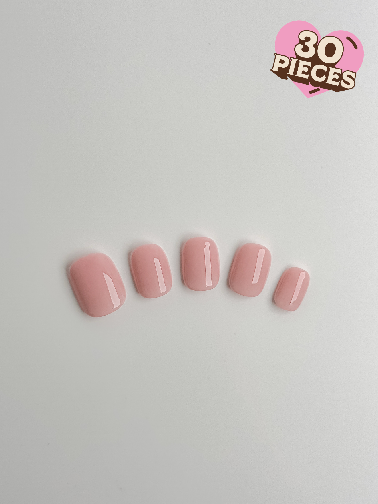 Five short square press-on nails in a translucent strawberry milkshake pink with a high-gloss finish